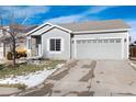 Gray house with a two-car garage and a partially snow-covered lawn at 3564 S Jebel Cir, Aurora, CO 80013