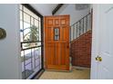 Foyer view featuring a wooden front door and staircase with brick accents at 3000 S Newland St, Denver, CO 80227