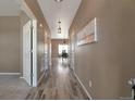 Inviting hallway with light wood floors leading to the dining area, creating a seamless transition throughout the home at 6472 N Dunkirk Ct, Aurora, CO 80019