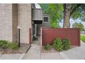 Exterior entryway of a charming home featuring a brick accent wall and a small courtyard with greenery at 1254 S Yosemite Way # 99, Denver, CO 80247