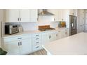 Bright kitchen featuring white cabinetry, stainless steel appliances, and a subway tile backsplash at 188 S Waterloo St, Aurora, CO 80018