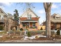 Charming brick home with a front porch and snow-covered yard at 3050 N Gaylord St, Denver, CO 80205