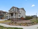 A view of this two-story home showing a fenced yard with natural landscaping at 9446 Quintero St, Commerce City, CO 80022