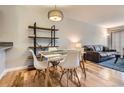 Bright dining area showcasing a stylish table and shelving unit, with views into the living room at 1818 S Quebec Way # 11-8, Denver, CO 80231