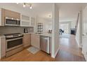 Well-equipped kitchen with stainless steel appliances, sleek cabinets, and an open view to the living room at 1818 S Quebec Way # 11-8, Denver, CO 80231