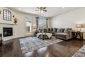 Cozy living room with hardwood floors, a fireplace, a comfortable sectional sofa, and a view of the backyard at 16201 Lanceleaf Pl, Parker, CO 80134