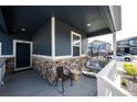 Inviting front porch featuring stylish seating, stone accents, and a welcoming entrance at 3722 Sandy Vista Trl, Castle Rock, CO 80104