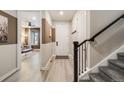 Welcoming entryway featuring sleek floors, staircase, and natural light filtering through nearby living area at 9742 Taylor River Cir, Littleton, CO 80125