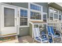 This is a view of a front door with a small patio area, complete with chairs for relaxing outside the home at 8199 Welby Rd # 3102, Denver, CO 80229