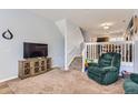 Inviting living room with plush carpeting, comfortable seating, and a large TV at 8199 Welby Rd # 3102, Denver, CO 80229