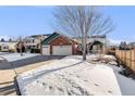 Two-story house with a three-car garage and snow-covered yard at 10976 W 55Th Ln, Arvada, CO 80002