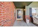 Front entrance with brick columns and a glass storm door at 10976 W 55Th Ln, Arvada, CO 80002