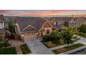 Attractive exterior home view featuring a well-kept lawn, landscape, a two-car garage and a driveway at 10221 Nucla St, Commerce City, CO 80022