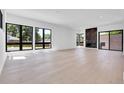 Spacious living room with large windows, light hardwood floors, and a stylish fireplace for a modern feel at 1491 S York St, Denver, CO 80210