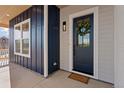 Inviting front entryway featuring a stylish blue door adorned with a green wreath, complemented by wood accents at 1426 Swan Peter Dr, Berthoud, CO 80513
