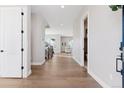 Bright and open hallway featuring hardwood floors, white walls, and a view of the staircase and living area at 1426 Swan Peter Dr, Berthoud, CO 80513