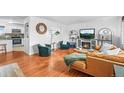 Bright living room featuring hardwood floors, a fireplace, and an open layout at 9395 W Kentucky Ave, Lakewood, CO 80226