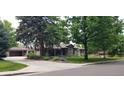Beautifully landscaped home featuring a detached garage and mature trees at 801 S Steele St, Denver, CO 80209