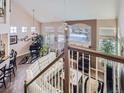 Open-concept living room with a piano, fireplace, and vaulted ceilings at 2676 S Troy Ct, Aurora, CO 80014