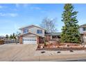 Charming two-story home featuring a well-manicured front yard and an attached two-car garage at 1691 S Arbutus Pl, Lakewood, CO 80228