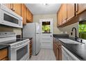 Efficient kitchen featuring wooden cabinets, white appliances, and a window-door leading to the outside at 3720 S Fairplay Way, Aurora, CO 80014