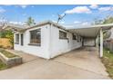 Exterior view of a single story house featuring white siding, a carport, and well-lit windows at 7760 Magnolia St, Commerce City, CO 80022