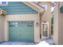A close-up view of a well-maintained home exterior featuring a single-car garage and front door at 11932 W Long Cir # 202, Littleton, CO 80127