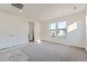Bright bedroom featuring neutral carpet, ample natural light, and two closets at 3172 S Russell St, Morrison, CO 80465