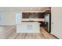 Modern kitchen with stainless steel appliances, dark cabinets, and a large center island at 3172 S Russell St, Morrison, CO 80465