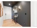 Bright entryway with dark shiplap feature wall, console table, and light wood flooring at 3589 Rucksack Ct, Castle Rock, CO 80108