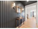 Modern entryway with dark shiplap accent wall, wood-toned console table, and light wood flooring at 3589 Rucksack Ct, Castle Rock, CO 80108