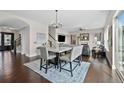 Dining room next to staircase features modern chandelier and flows into living room at 10468 Ladera Dr, Lone Tree, CO 80124