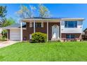 Inviting two-story brick home featuring a covered front porch, well-kept lawn, and solar panels on the roof at 1081 E 119Th Pl, Northglenn, CO 80233