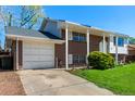 Charming two-story home with a brick facade, attached garage, and inviting front porch at 1081 E 119Th Pl, Northglenn, CO 80233