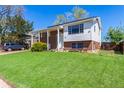 Charming two-story home with a brick facade, manicured lawn, and inviting front porch at 1081 E 119Th Pl, Northglenn, CO 80233