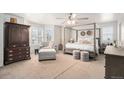Serene main bedroom featuring a four-poster bed, plush carpeting, and large windows with plantation shutters at 13340 Saint Paul St, Thornton, CO 80241