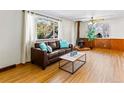 Cozy living room featuring hardwood floors, a fireplace, and a large window at 1050 Youngfield St, Golden, CO 80401