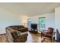 Cozy living room featuring modern wood floors, natural light, and comfortable seating at 11200 W 102Nd Ave, Broomfield, CO 80021