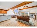 Bright living room featuring hardwood floors, wood beams, fireplace, and natural light from skylight windows at 163 Ward Ct, Lakewood, CO 80228