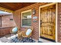 Inviting front porch with seating area, stylish rug, and natural wood front door at 2039 S Sherman St, Denver, CO 80210