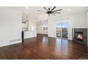 Open concept living space with view of modern kitchen, fireplace, hardwood floors, and ceiling fan at 1405 Willow Oak Rd, Castle Rock, CO 80104