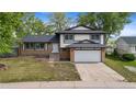 Inviting two-story house boasts a brick facade, a lush green lawn, and an attached two-car garage at 12992 W Jewell Cir, Lakewood, CO 80228
