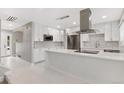 Open-concept kitchen with stainless appliances, white cabinets, and marble tile flooring at 12992 W Jewell Cir, Lakewood, CO 80228