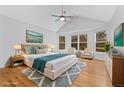 Bedroom with vaulted ceiling, multiple windows, ceiling fan, and hardwood floors at 627 Millbrook Cir, Castle Rock, CO 80109