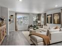 Bright living room featuring modern decor, large windows, and neutral color palette at 14492 Pansy Loop, Morrison, CO 80465