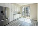 Modern kitchen with white cabinets, stainless steel appliances, and sliding glass doors to the outside at 8722 E 47Th Ave, Denver, CO 80238