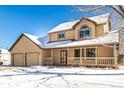 Two-story house with beige siding, double garage, and a covered porch in the snow at 1506 Maple Dr, Berthoud, CO 80513