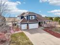 Inviting home featuring a three-car garage, a covered porch, and professional landscaping at 5202 Fairfield Cir, Castle Rock, CO 80104