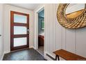 Inviting entryway with modern door, decorative mirror, and stylish wood accents creates a warm, welcoming atmosphere at 8540 W 59Th Ave, Arvada, CO 80004