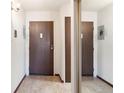 Hallway entryway with doors, laminate flooring, and utility access panel at 3470 S Poplar St # 401, Denver, CO 80224